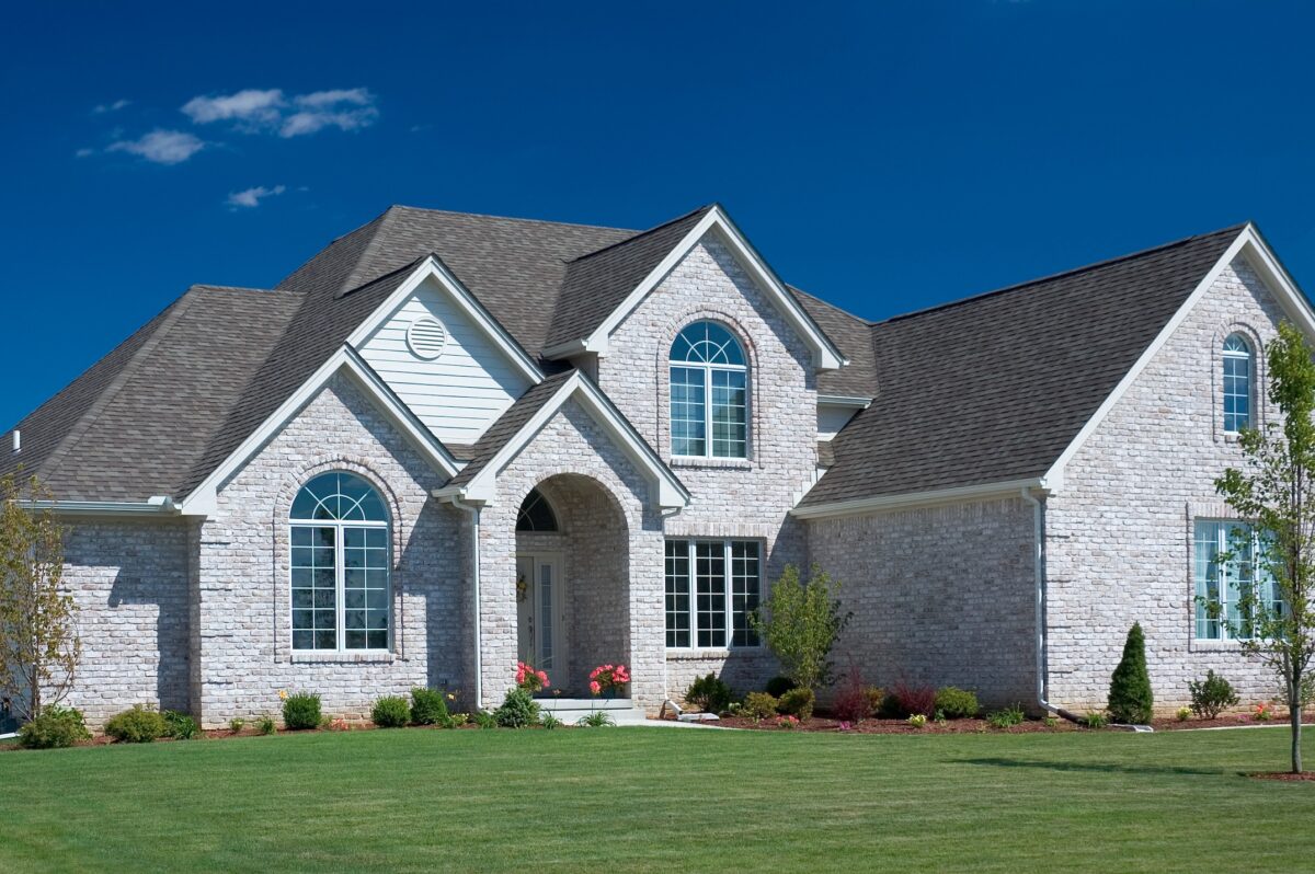 Beautiful white brick home featuring some fantastic brick details, Nice blue sky background to set the photo off nicely.