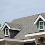 Roof shingles with garret house on top of the house. dark asphalt tiles on the roof background on afternoon time. dark asphalt tiles on the roof background