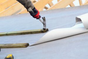 Joiner working on a new house roof making it ready roof tiles or slates roofing tools