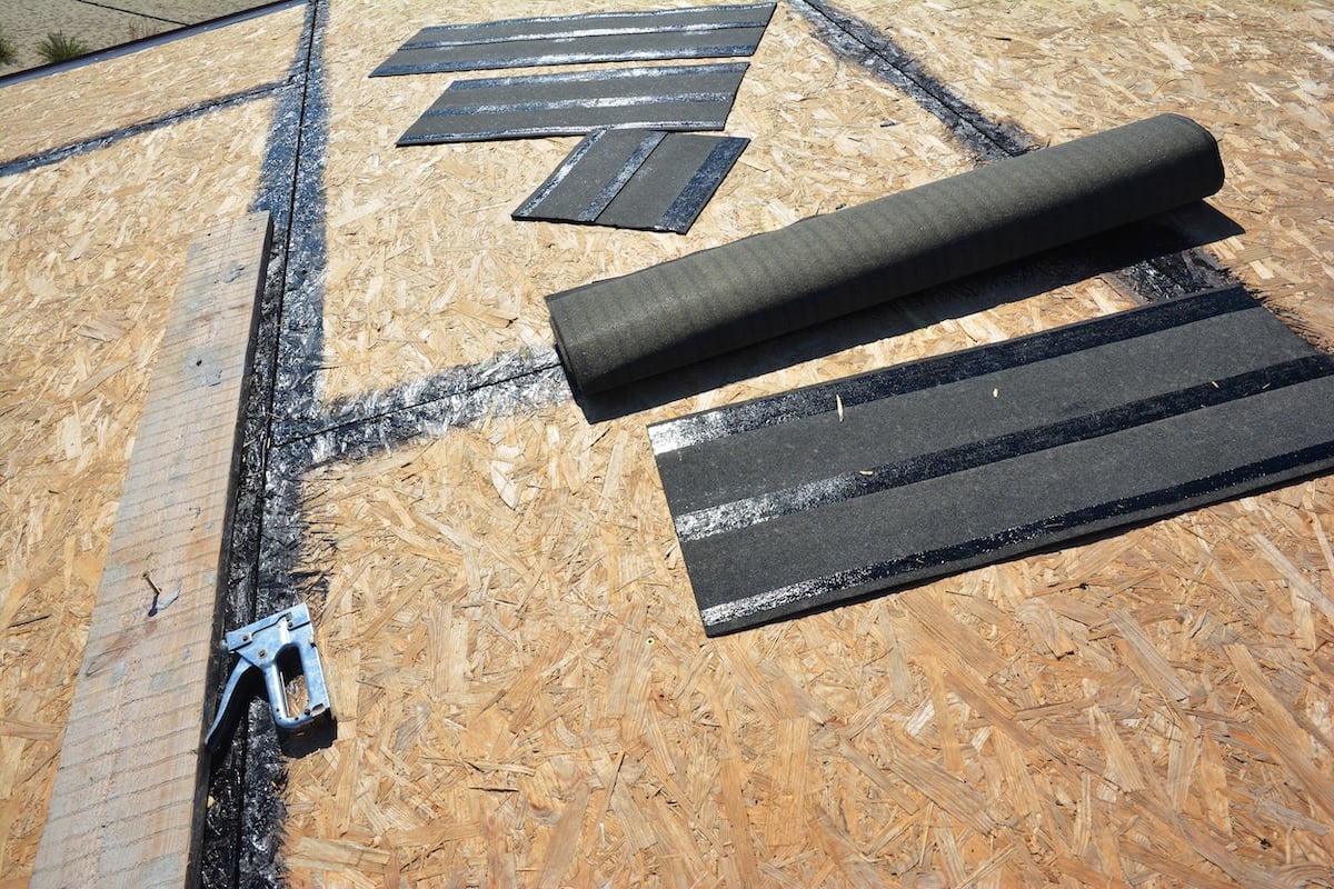 Preparing a roof deck and working tool stapler, having the surface of the roof sheathing clean and smooth before underlayment, felt paper and asphalt shingles installation. roof sheathing