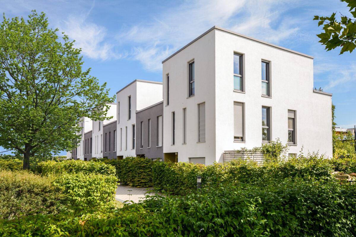 Modern townhouses in a residential area, new apartment buildings with green outdoor facilities in the city flat roof replacement