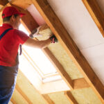 house attic insulation - construction worker installing rock wool in mansard wall