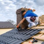 a professional master (roofer) with electric screwdriver covers repairs the roof