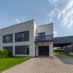 Exterior of modern luxury private house. Garage entrance. Canopy. Blue sky. Sunny day.