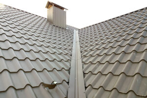 Close up of new house roof structure covered with metal tile sheets.