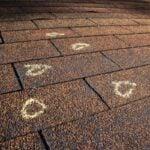 Insurance Adjuster marked hail damage on a insureds roof.