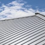 Metal sheet roof and slope with clouds and blue sky background