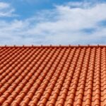 Red tiles panels roof under blue sky
